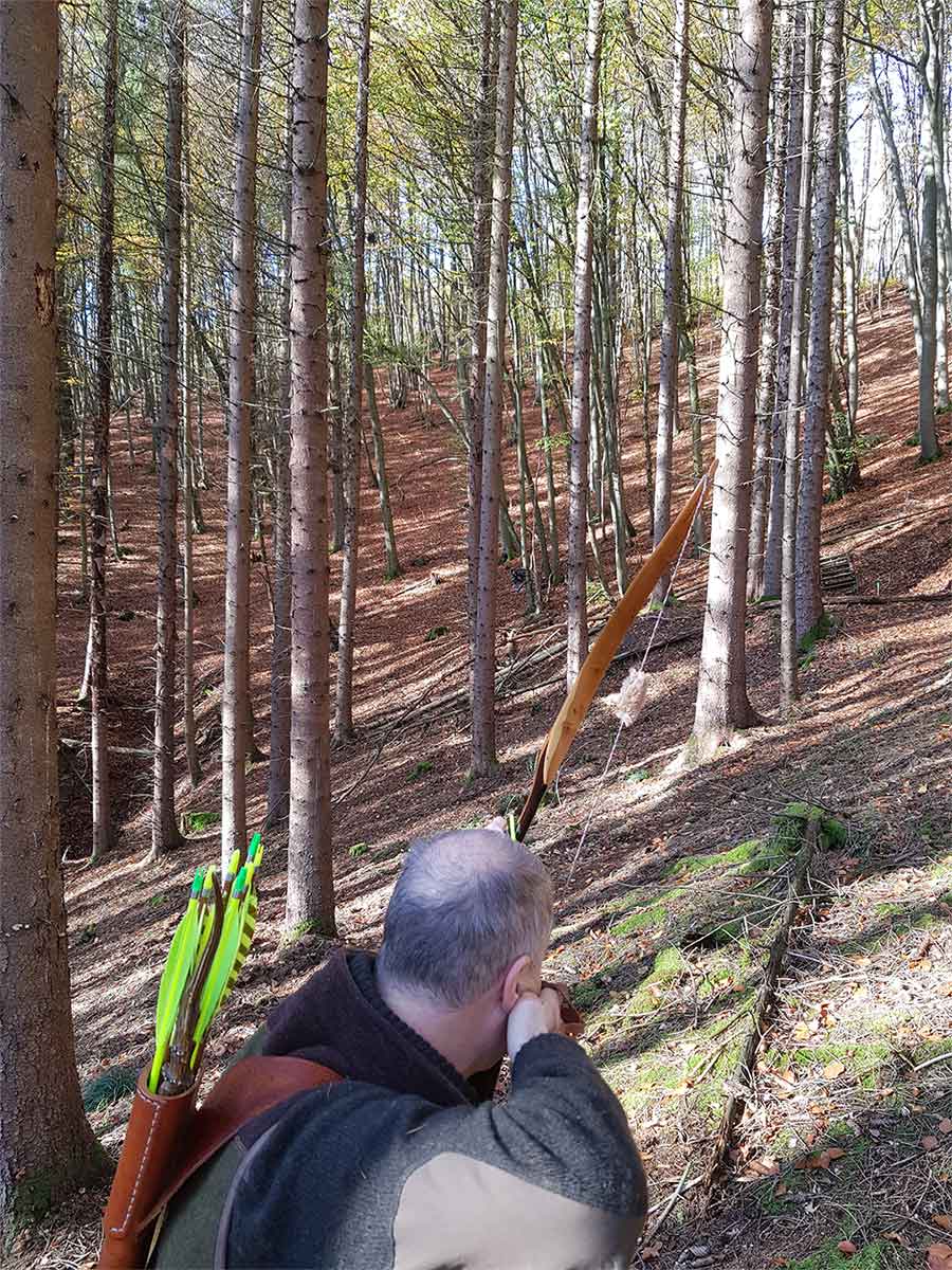 Bogenschütze bei seiner Freizeitbeschäftigung Bogenschießen im Parcours im Wald